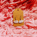 Gold earrings with cloud charm and a gold earrings post on a pink fluffy fabric background
