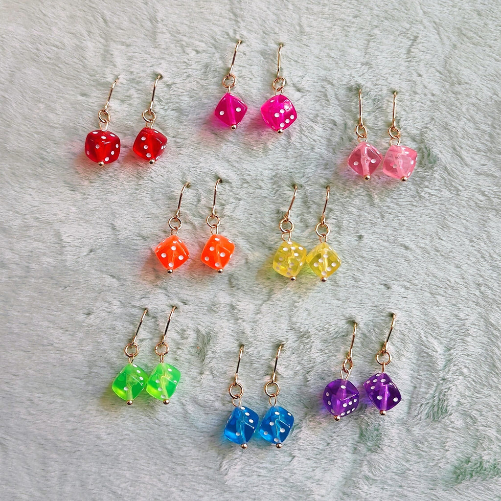 Colorful beaded earrings on a wooden hoop with a blue textured background