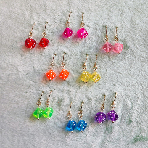 Colorful beaded earrings on a wooden hoop with a blue textured background
